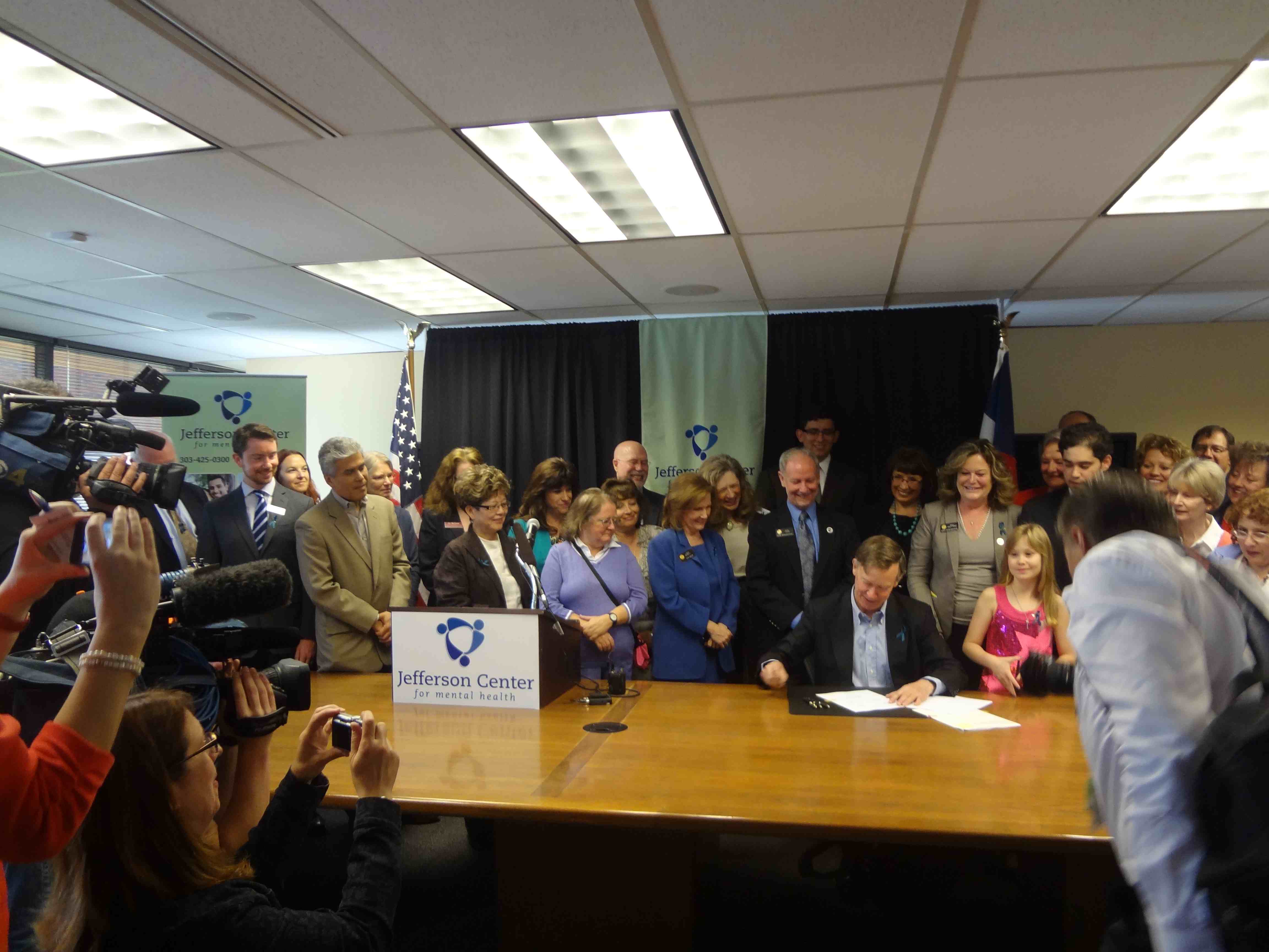 Hickenlooper and behavioral health leaders from across Colorado attend the signing of HB 13-1296 and SB 13-266 at the Jefferson Center for Mental Health on May 16. (Photo courtesy Michael Lott-Manier.)